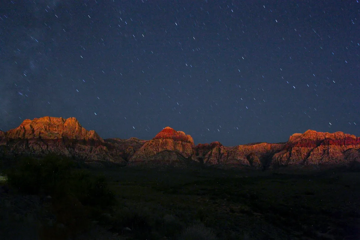 Stars over red rock cliffs in the Southern Nevada desert at night