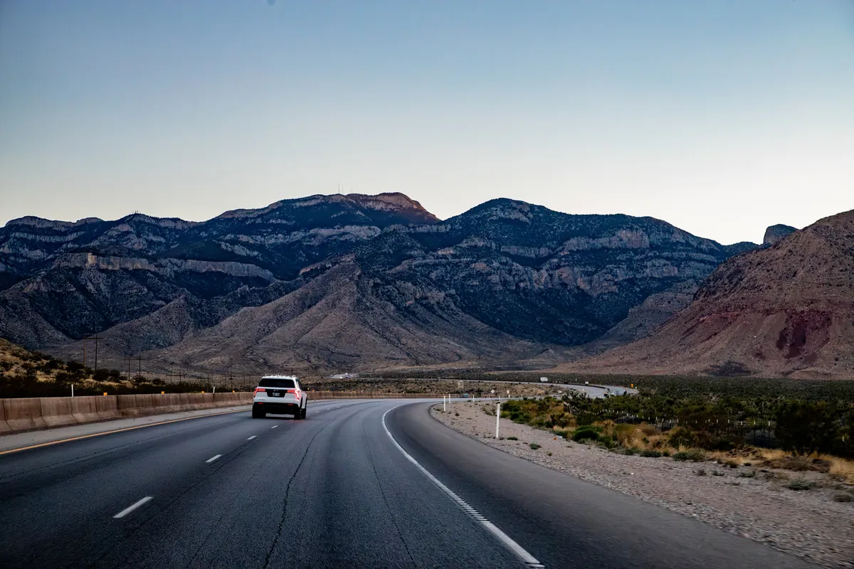 The highway curving toward the Spring Mountains on the drive into the Pahrump Valley